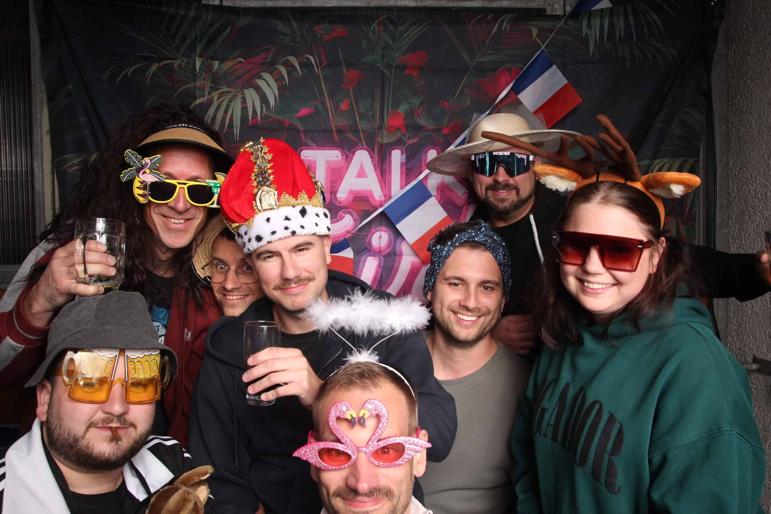 Freundliche Gruppe feiern 30. Geburtstag mit lustigen Kostümen und Dekorationen, Party in Deutschland, Freunde mit Partyaccessoires und Flaggen.