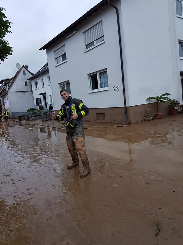 Rettungskraft im Hochwasser in einem Wohngebiet während einer Flutkatastrophe.