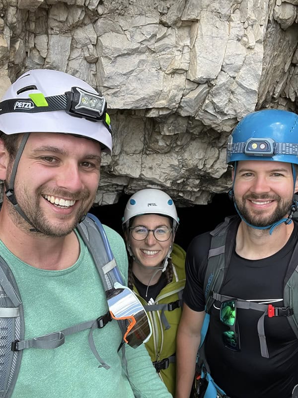 Abenteuerliche Klettertour in der Höhle mit Tourenhelmen und Kletterausrüstung, Naturerlebnis im Felsen.
