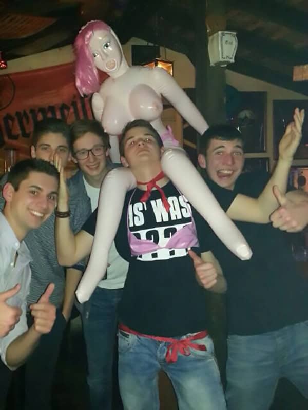 Junge Männer feiern Geburtstag mit lustigem Onigiri-Schwanz-Geburtstagsdekoration in Bar.