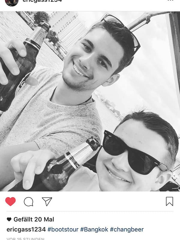 Hintergrund: Stadtbild und Wasser, zwei junge Männer tragen Sonnenbrillen, feiern mit Bier, fröhlich, Sommer, Freundschaft, urbanes Lifestyle.