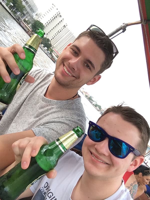 Feierliches Geburtstagsbild mit Freunden, die Bier trinken, fröhliche Stimmung, Feier am Wasser, jung, modern, Spaß, Sommer, Party, Freundschaft.