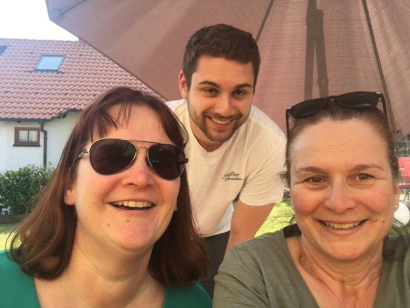 Glückliche Geburtstagsfeier im Garten mit Freunden, entspannte Atmosphäre, sonniger Tag, Freude und Zusammenkunft.