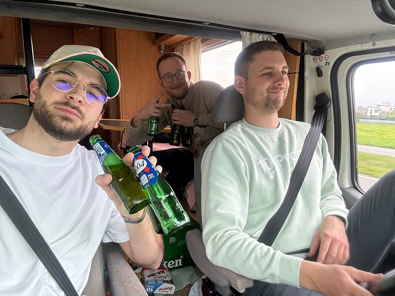 Beer trinken bei einer Fahrt im Auto, Freunde feiern Geburtstag, entspannte Stimmung, Party unterwegs, junge Männer mit Getränken, fahrende Geburtstagsfeier.