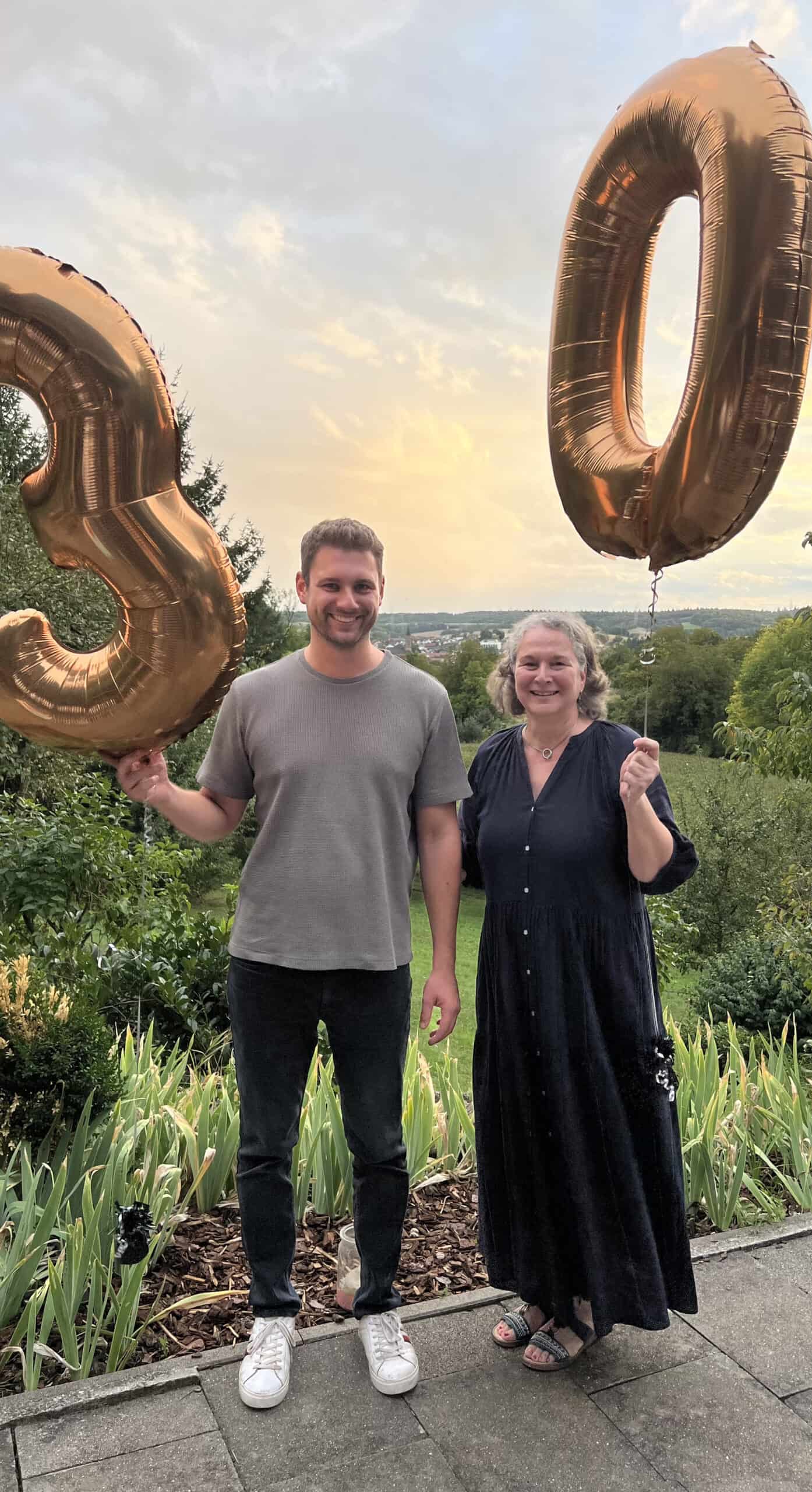 Luftballons in Gold ‚30‘ bei Geburtstagsfeier im Freien.