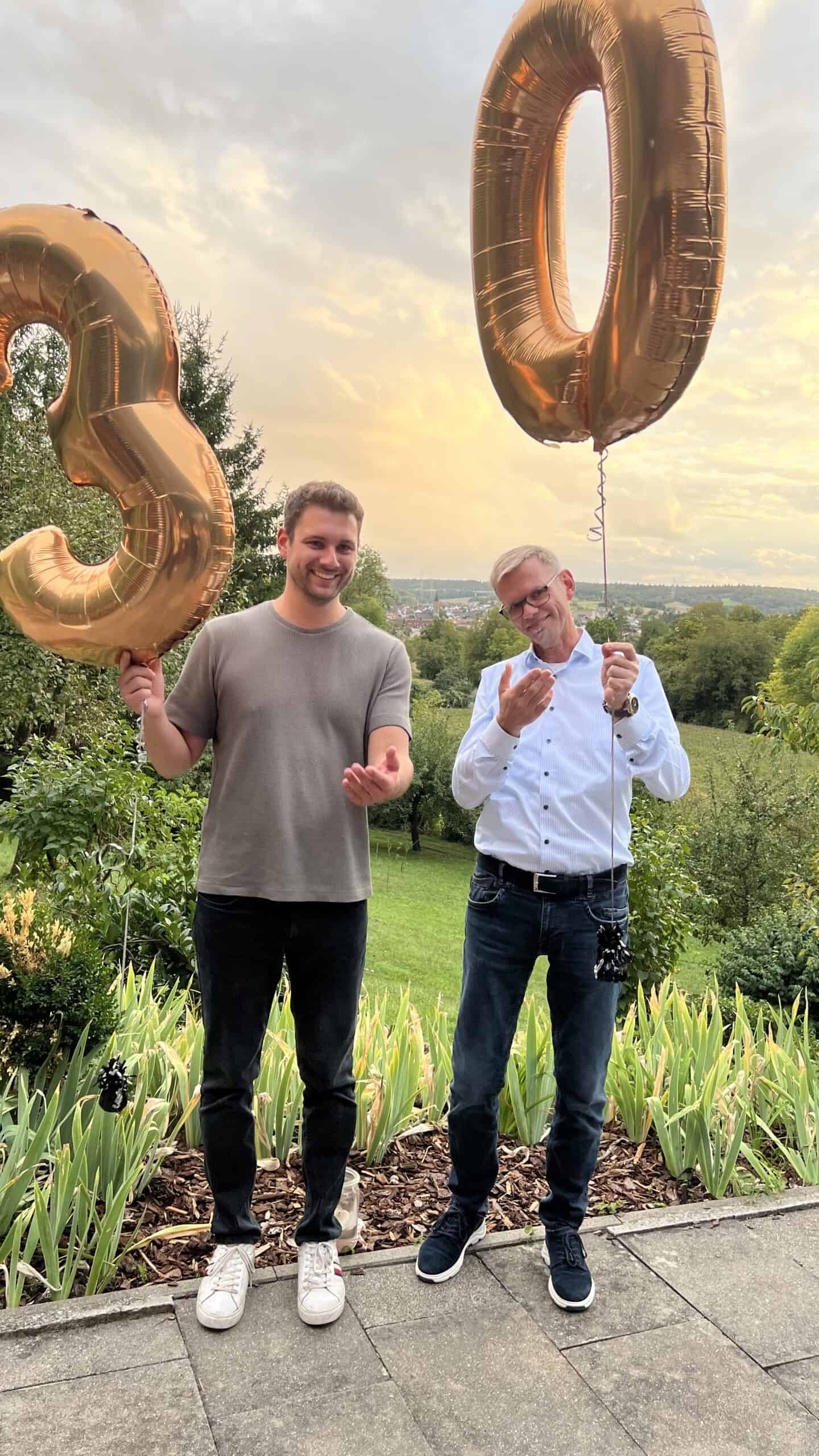 Großer 30. Geburtstag, zwei Männer feiern mit goldenen Ballons in der Natur.