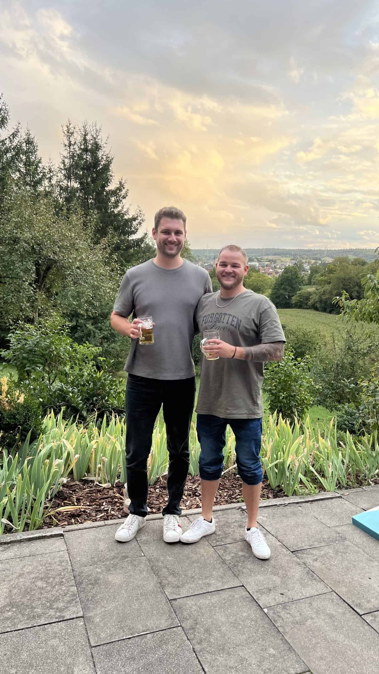 Fröhliche Männer beim Geburtstag im Grünen, mit Bier in der Hand, lachend und das Leben genießend.