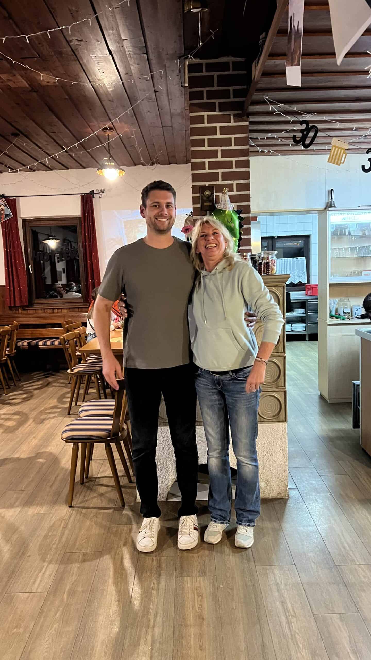 Glückliches Geburtstagsfoto mit Mutter und Sohn in gemütlicher Gaststätte, feiern den 30. Geburtstag.