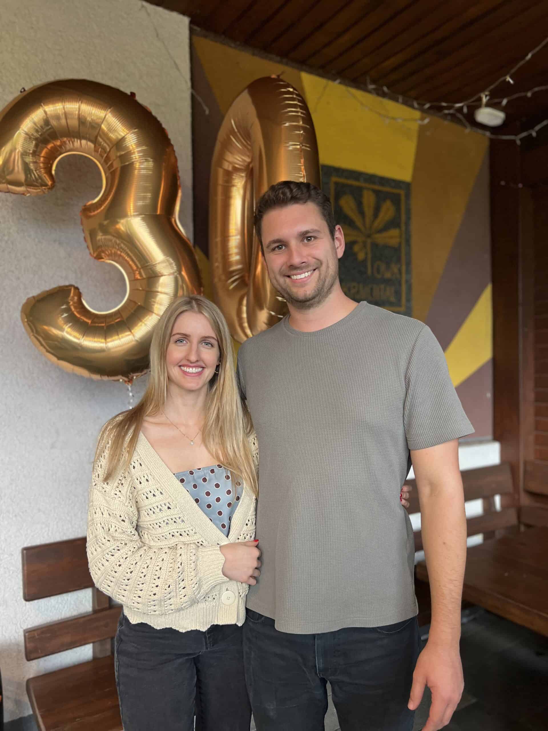 3. Glückliches Paar zum 30. Geburtstag mit goldenen Ballons, Feier in rustikalem Ambiente.