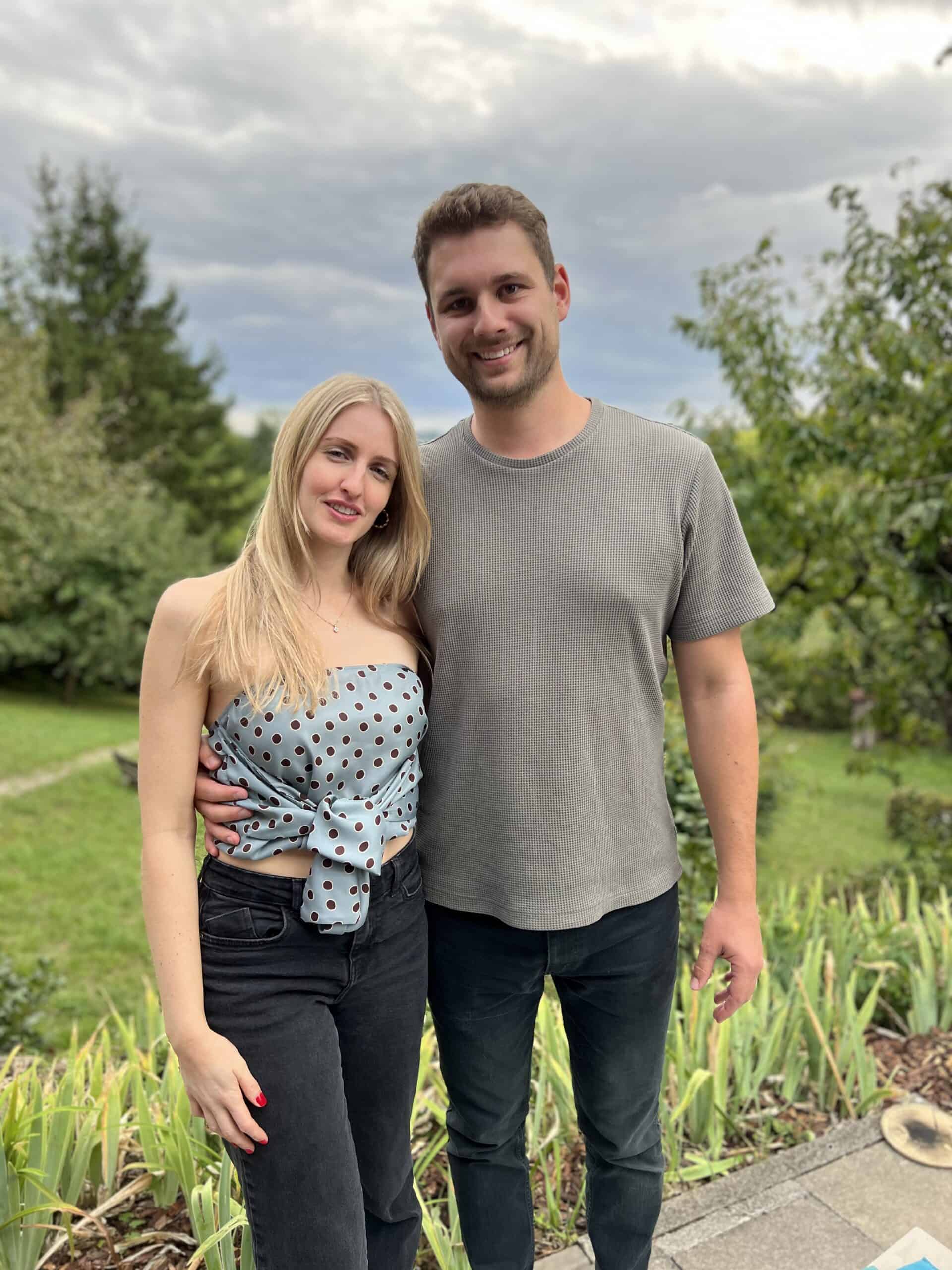 Junges Paar im Garten, Geburtstagsfeier, Natur, glückliches Paar, freundliche Stimmung.