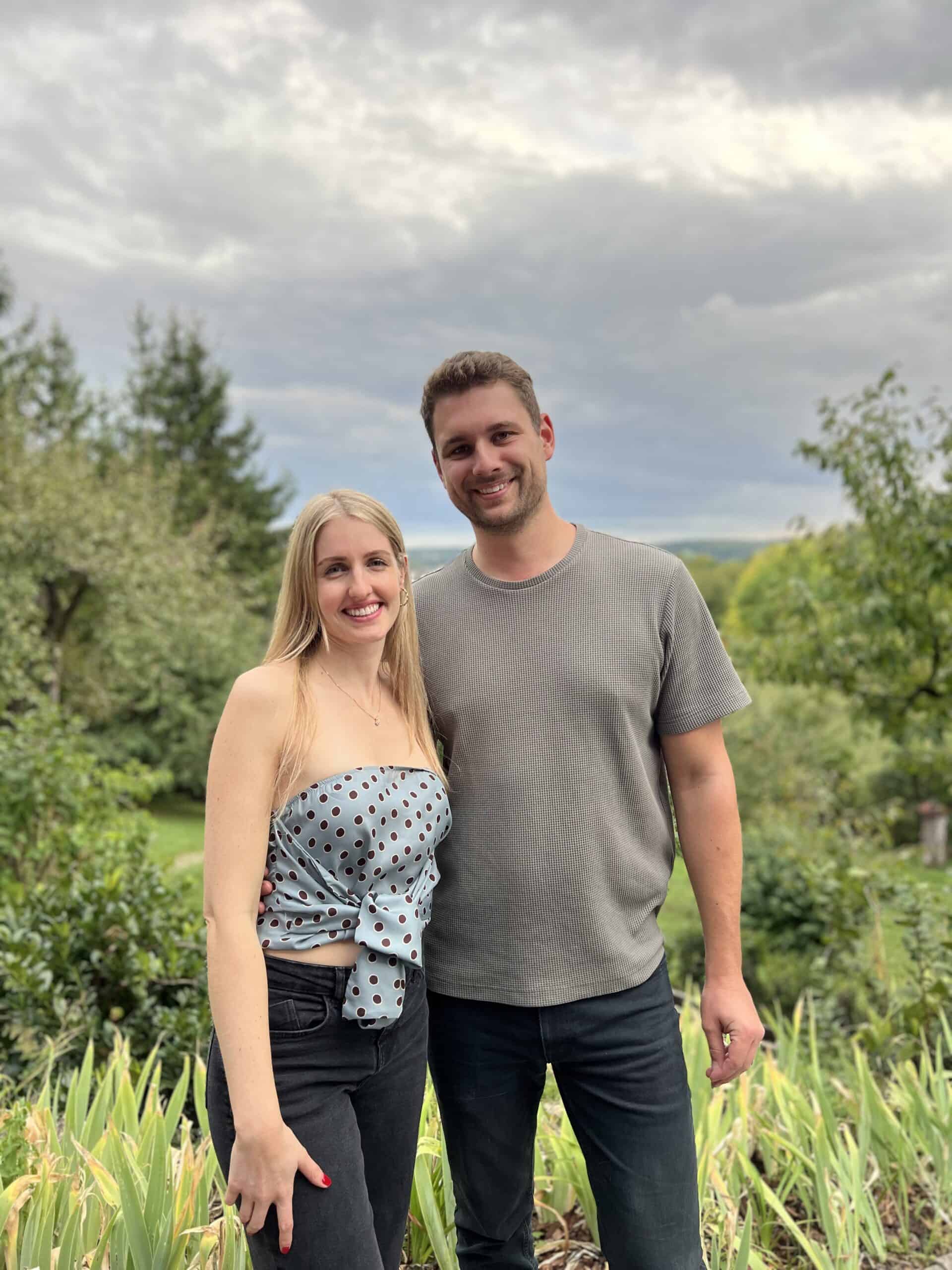 Strahlendes Paar im Grünen zum 30. Geburtstag, beide lächeln, fröhliches Geburtstagsfoto in der Natur, perfekt für Glückwünsche und Feierlichkeiten.